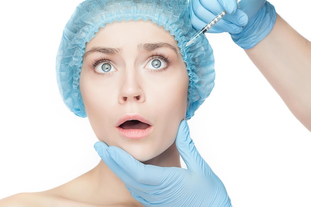 Donna attraente alla chirurgia plastica con una siringa in faccia