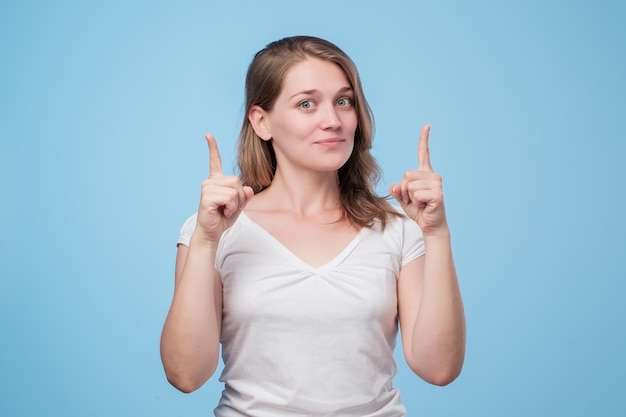 Photo attractive woman pointing up giving advice about right choice