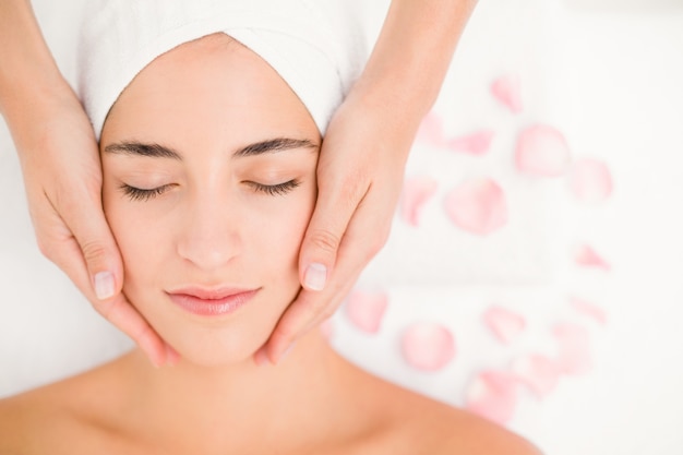 Attractive woman receiving facial massage at spa center