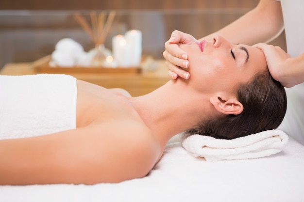attractive woman receiving head massage at spa center
