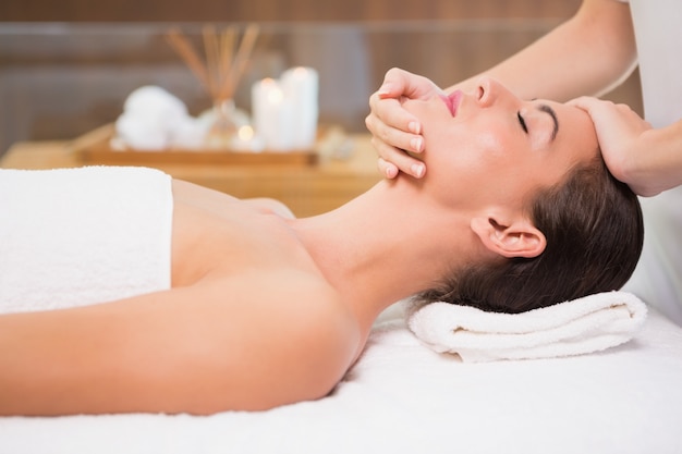 Attractive woman receiving head massage at spa center