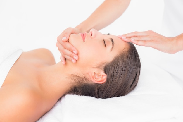 Donna attraente che riceve massaggio alla testa nel centro termale