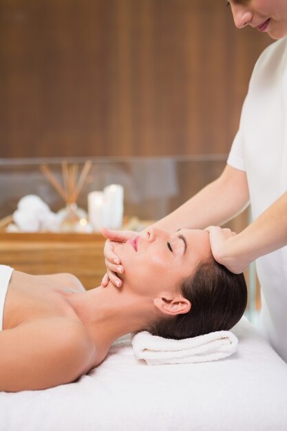 Attractive woman receiving head massage at spa center