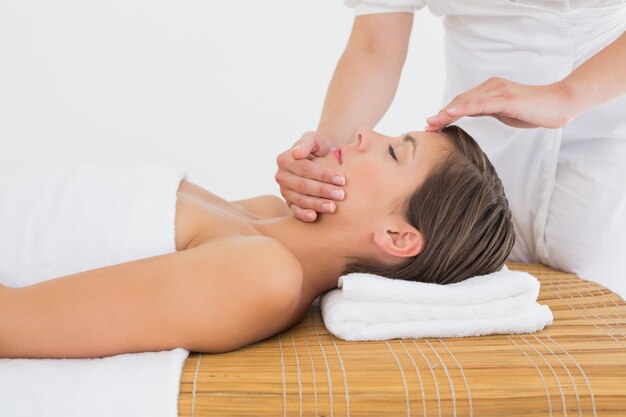 attractive woman receiving head massage at spa center