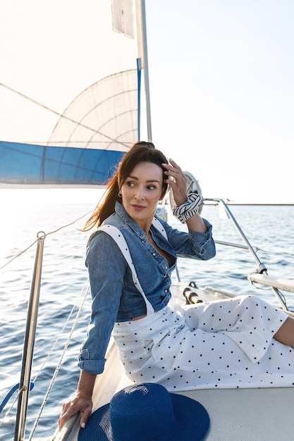 Foto donna attraente che si rilassa su una barca a vela durante la navigazione in mare