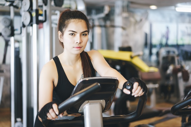 Donna attraente che guida sulla bici da spinning.