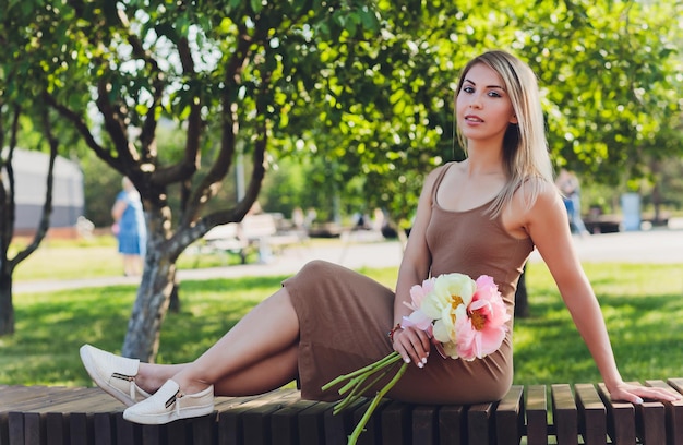 привлекательная женщина сидит о букет цветов пиона
