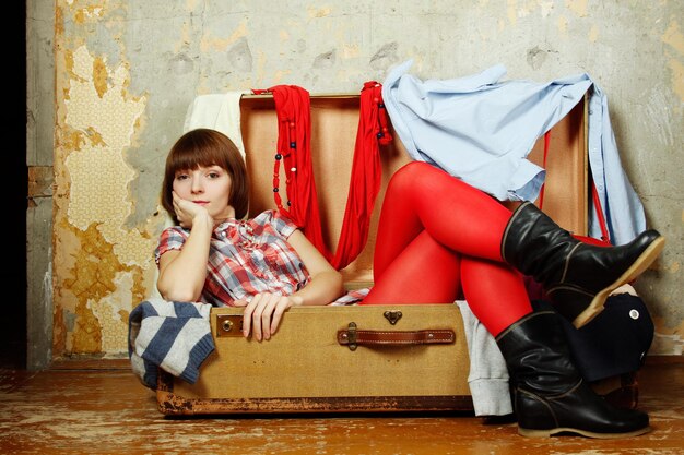 Привлекательная женщина сидит в чемодане