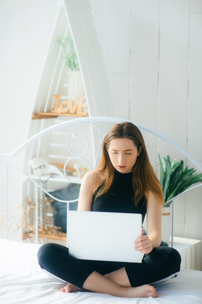 attractive woman using laptop and smiling at morning