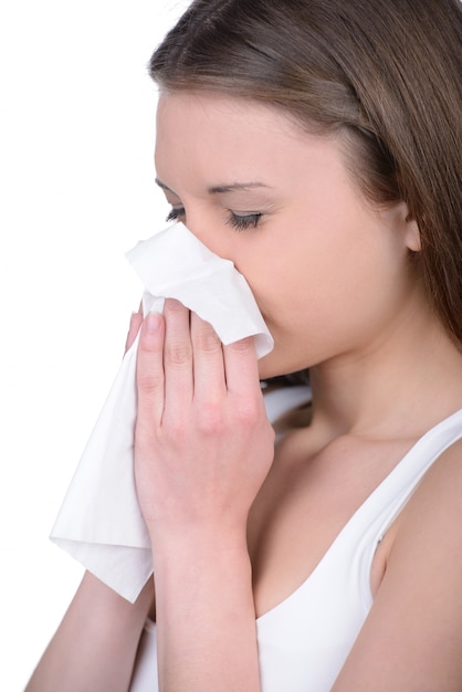 Attractive woman using tissue for nose.