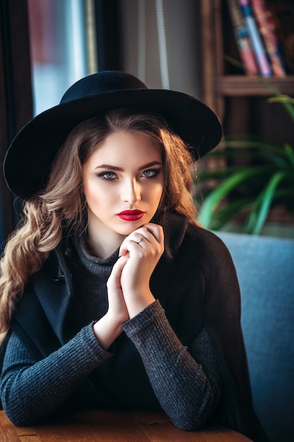 Attractive woman wearing stylish black hat.