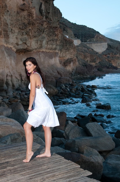 attractive woman in white dress on the seashore