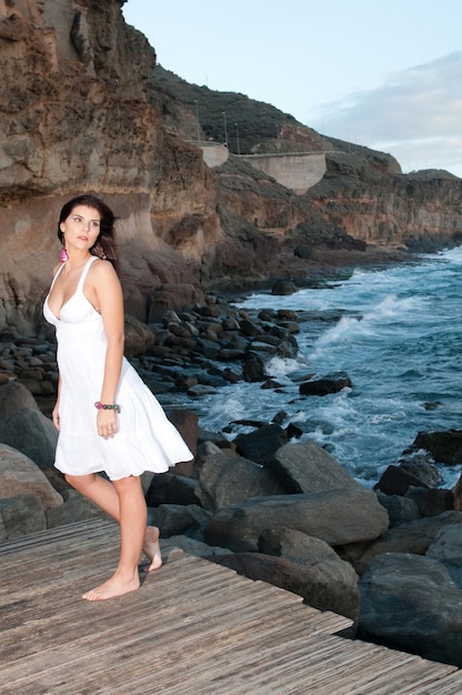 해변에서 하얀 드레스를 입은 매력적인 여자