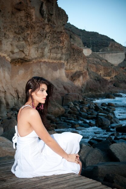 attractive woman in white dress on the seashore