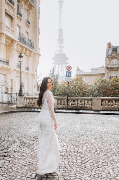 Attractive woman in a white dress walks down the street of Paris