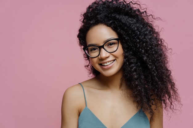 Donna attraente con i capelli afro folti sorrisi