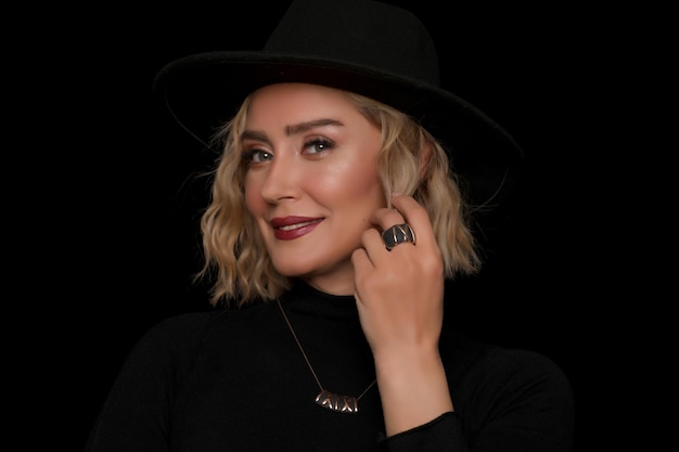 Photo attractive woman with black hat and blonde wavy hair showing her ring