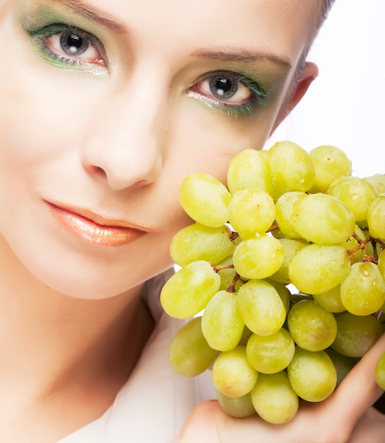 Attractive woman with bunch of grapes
