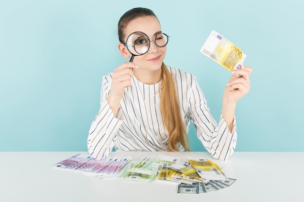 Attractive woman with cash and magnifying glass