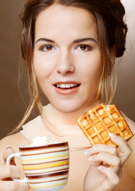 コーヒーとクッキーを持つ魅力的な女性