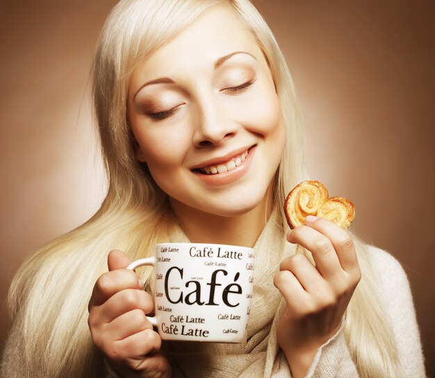 Attractive woman with coffee and cookies