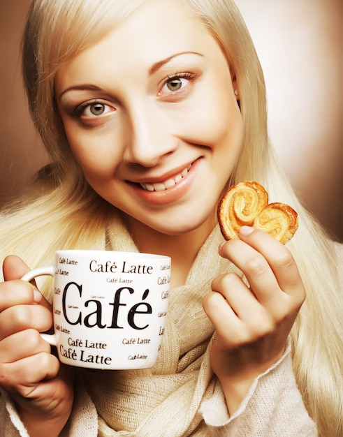 Donna attraente con caffè e biscotti