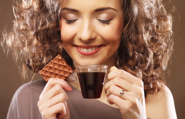 コーヒーとクッキーを持つ魅力的な女性