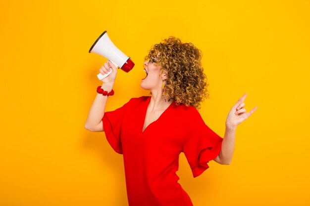 Attractive woman with curly hair with loudspeaker