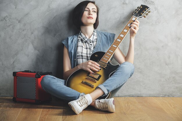 Attractive woman with guitar in studio