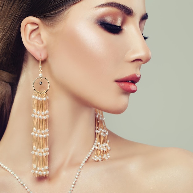 Attractive Woman with Makeup and Gold Earrings with Pearls Face Closeup Portrait