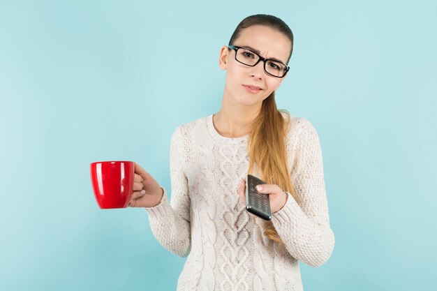 Attractive woman with ponytail and cup with remote