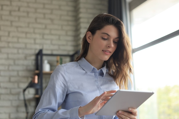 Attractive woman working on a tablet in a home office.