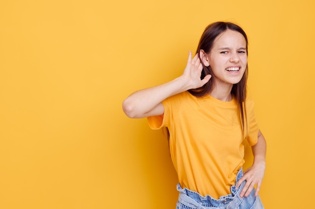 Attractive woman in a yellow tshirt emotions summer style yellow background