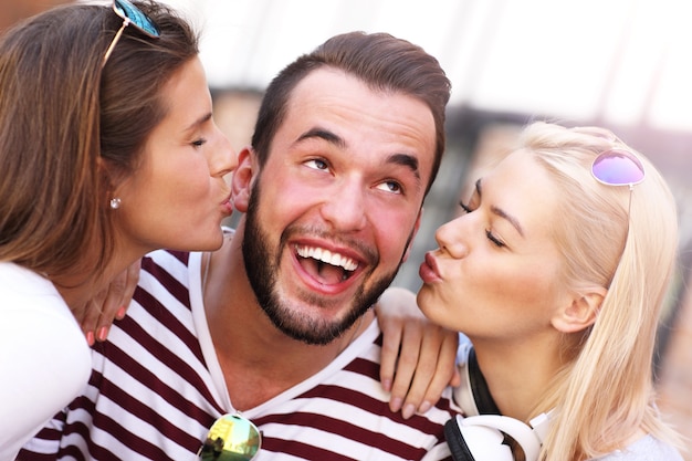 attractive women kissing a man in the city