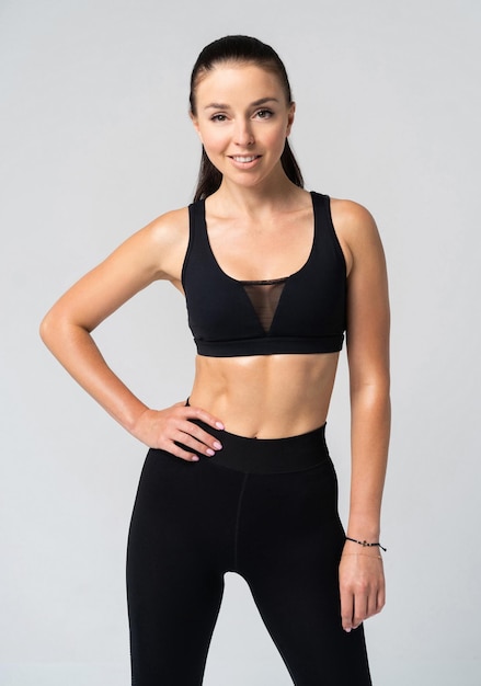 Attractive young adult in sportswear posing on white background