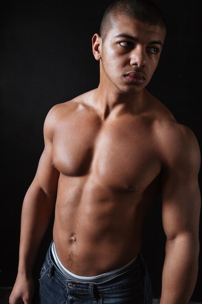 Attractive young african sportsman over black background