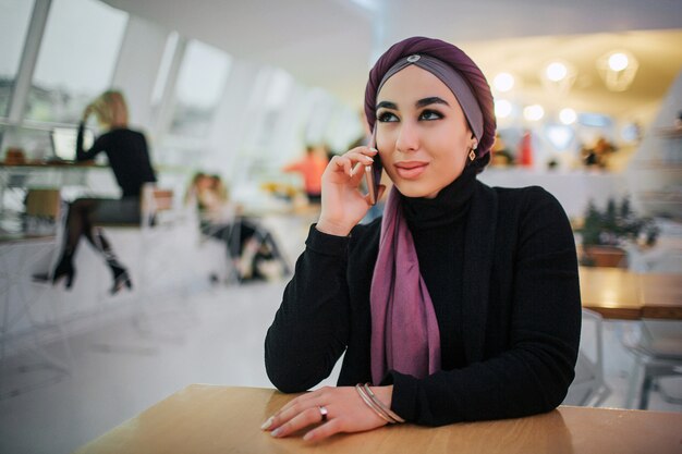 Photo attractive young arabian woman sit at table in cafe.