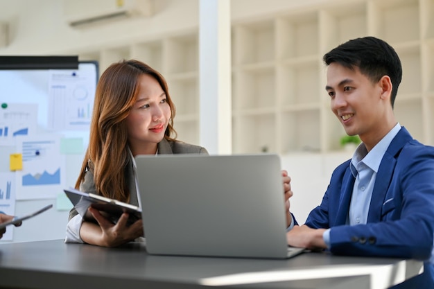 Attractive young Asian businesswoman discussing and working with a male project manager