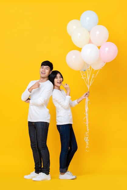 Attractive young Asian lover  holding colourful ballons 