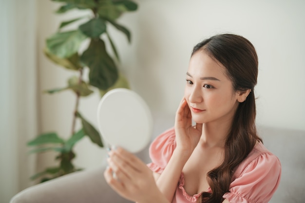 Attractive young asian woman isolated in living room