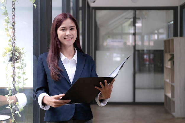 Attractive young asian woman using laptop computer while standing in a office