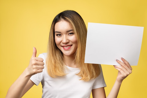Attractive young beautiful Asian student woman holding blank white paper.