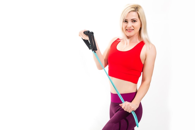 Attractive young blond woman exercising in a gym stretching and toning her muscles in a health and fitness concept