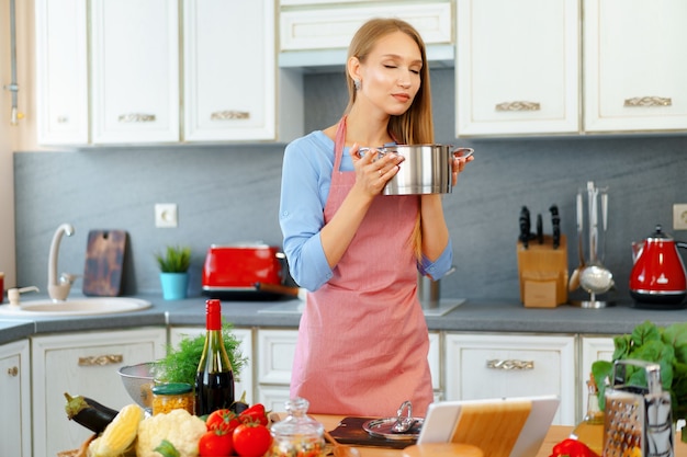 魅力的な若いブロンドの女性は調理済み食品をチェック