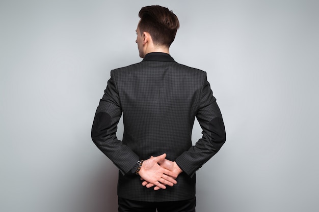 Photo attractive young businessman in black jacket, costly watch and black shirt