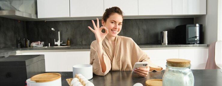 Photo アイデアを持ったレシピ本を持って生地を作るキッチンで焼く魅力的な若い陽気な女の子