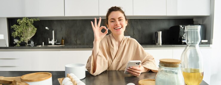 Photo アイデアを持ったレシピ本を持って生地を作るキッチンで焼く魅力的な若い陽気な女の子