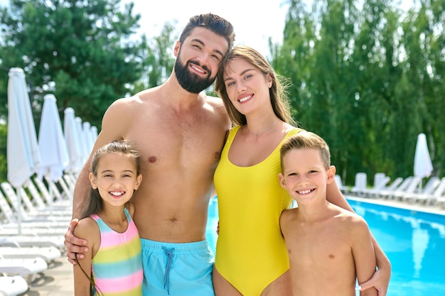 Foto una giovane coppia attraente che si diverte e si rilassa in vacanza in un resort che trascorre giorni pigri vicino alla piscina famiglia sorridente che si sente felice e spensierata