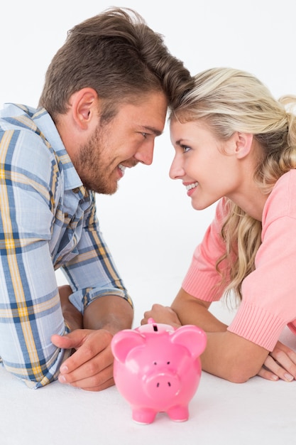 Photo attractive young couple with piggybank