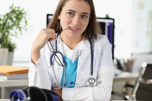 Attractive young doctor posing in personal office in clinic